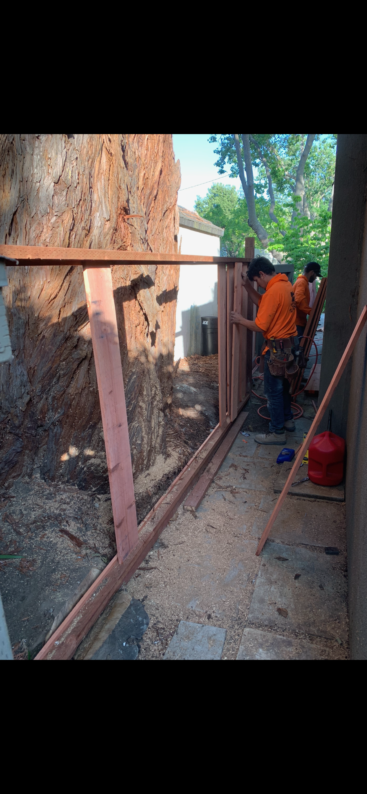 Crew framing a wood fence installation